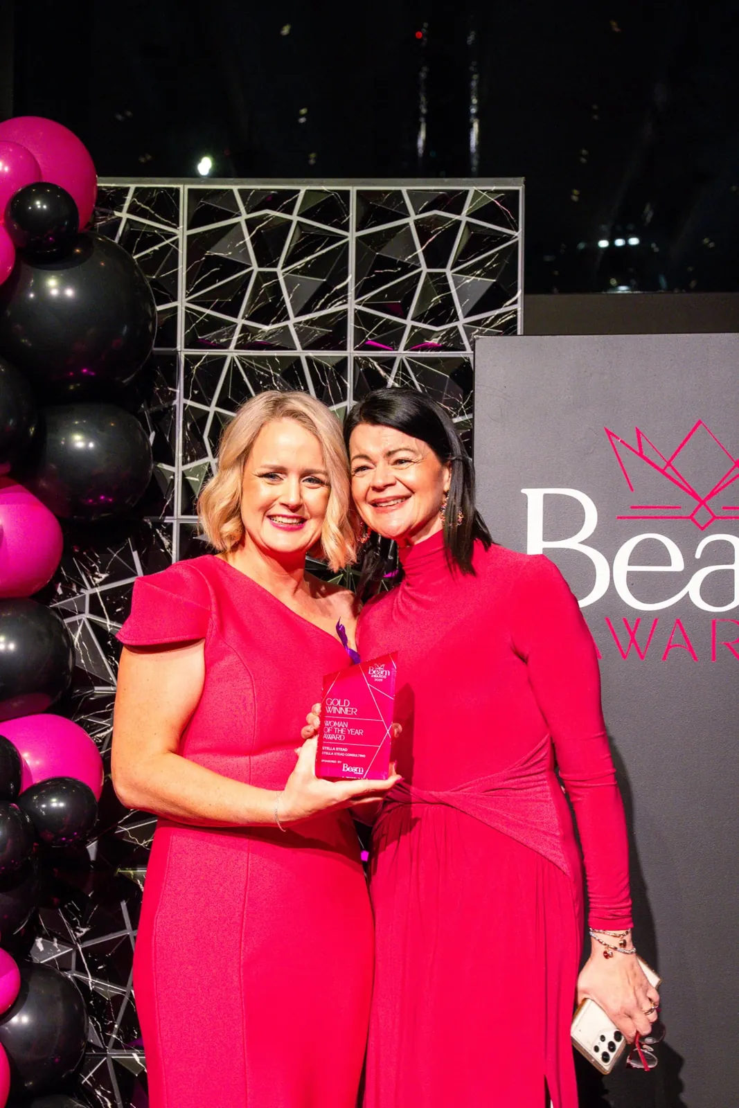 Two guests smiling with an award at the Gala