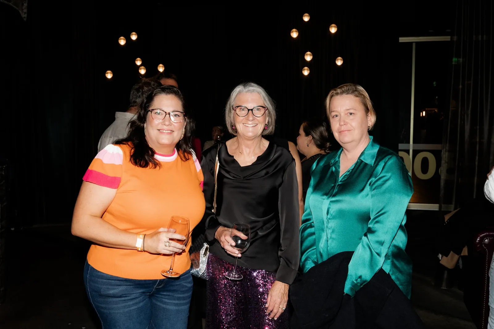 Guests smiling together at an evening event