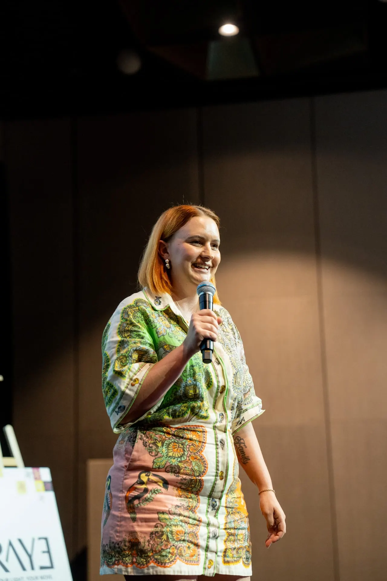 A business owner speaking on stage at RAYE Haus