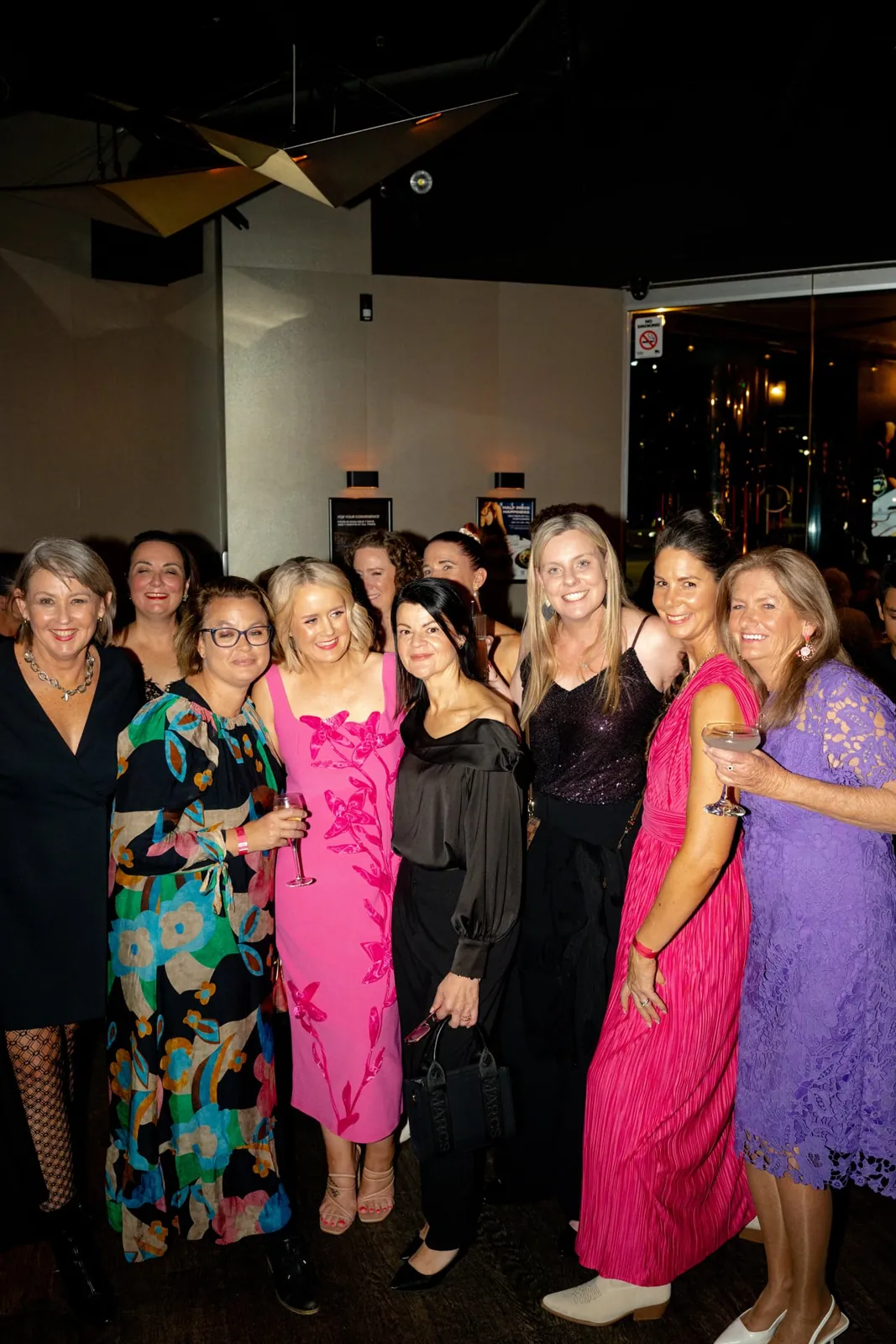 Friends gathered together in bright event outfits