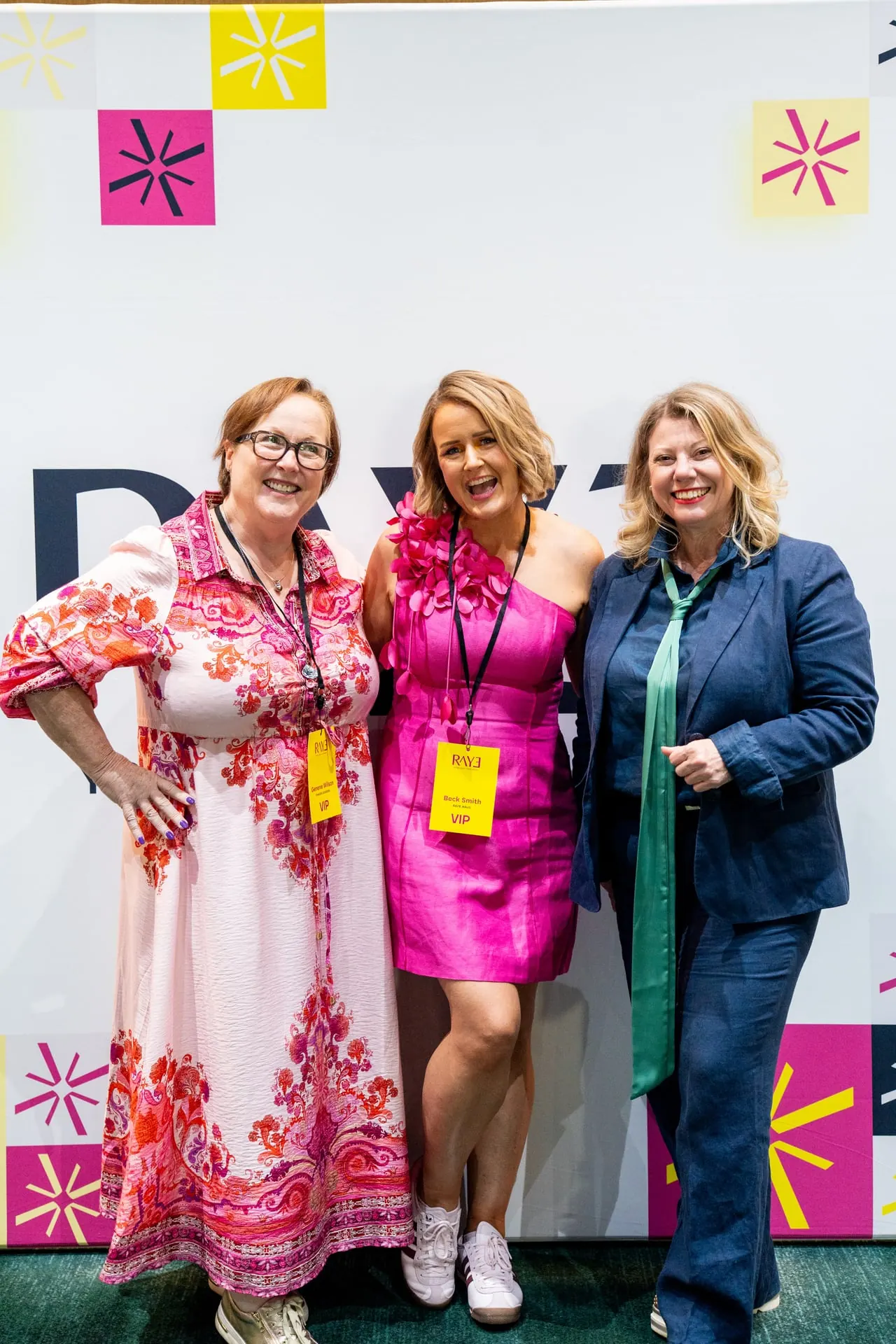 Three RAYE Haus guests together in front of the event wall
