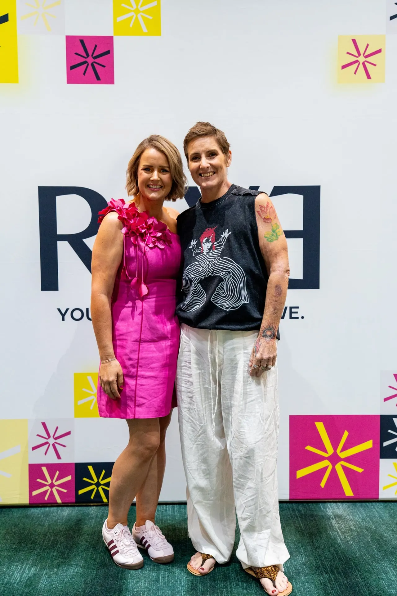Beck Smith with a member in front of the RAYE wall