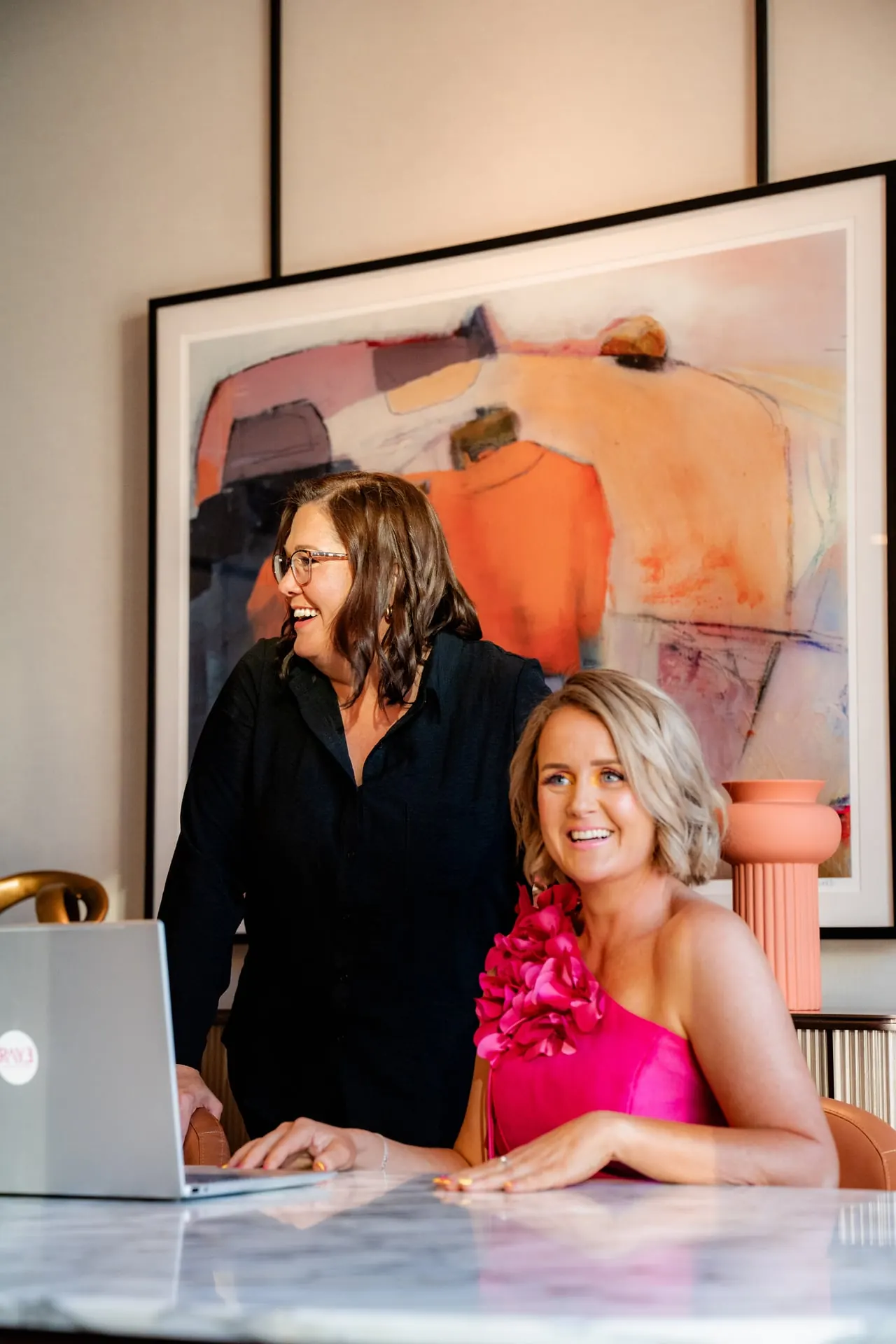 Two RAYE Haus members working together at a laptop