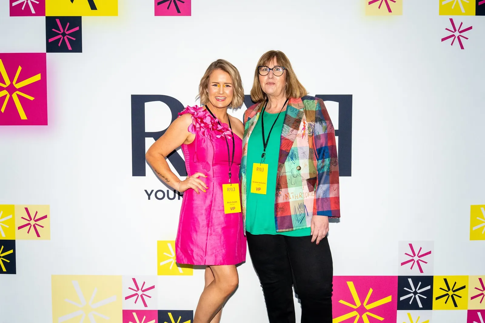 Two RAYE Haus members at the event photo wall