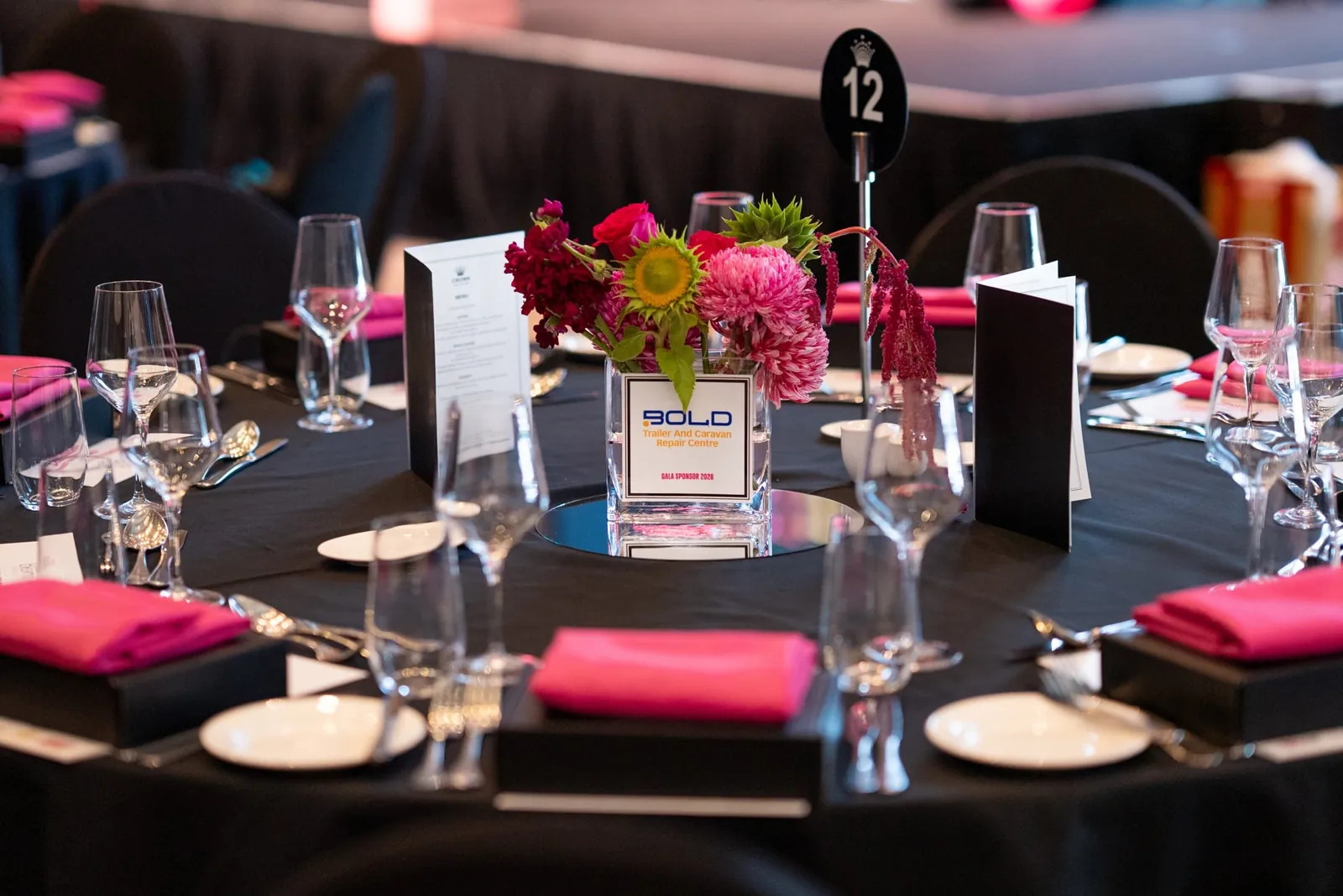 An Awards Gala table set with pink flowers and place settings
